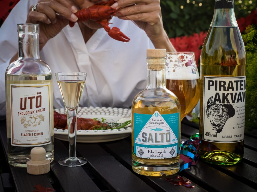 Swedish aquavit and snaps bottles on a table set for a crayfish feast